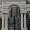 重厚な石造のアーチに組み込まれたクラッシクなデザインの重厚な門扉①